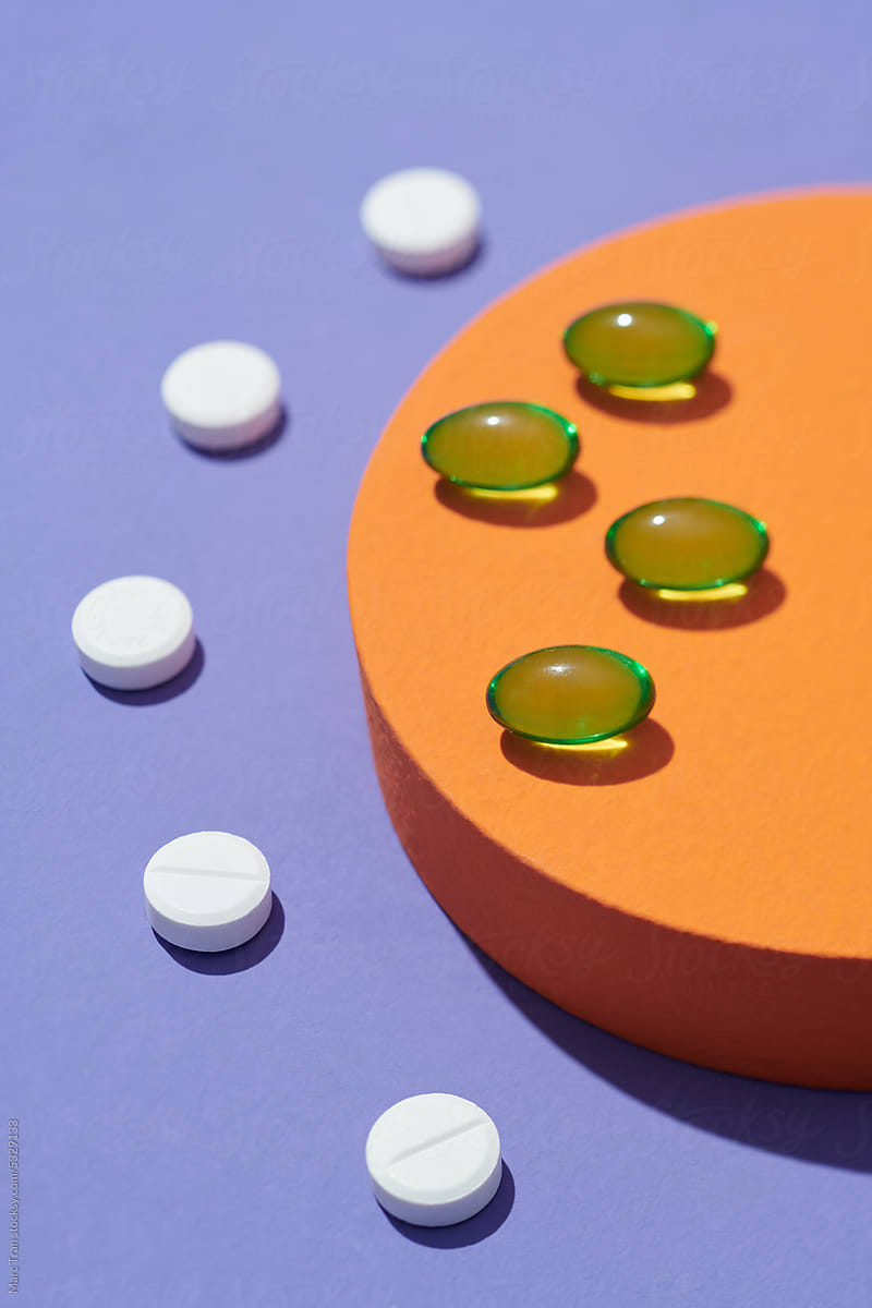 White round shape pills and jelly capsules on purple