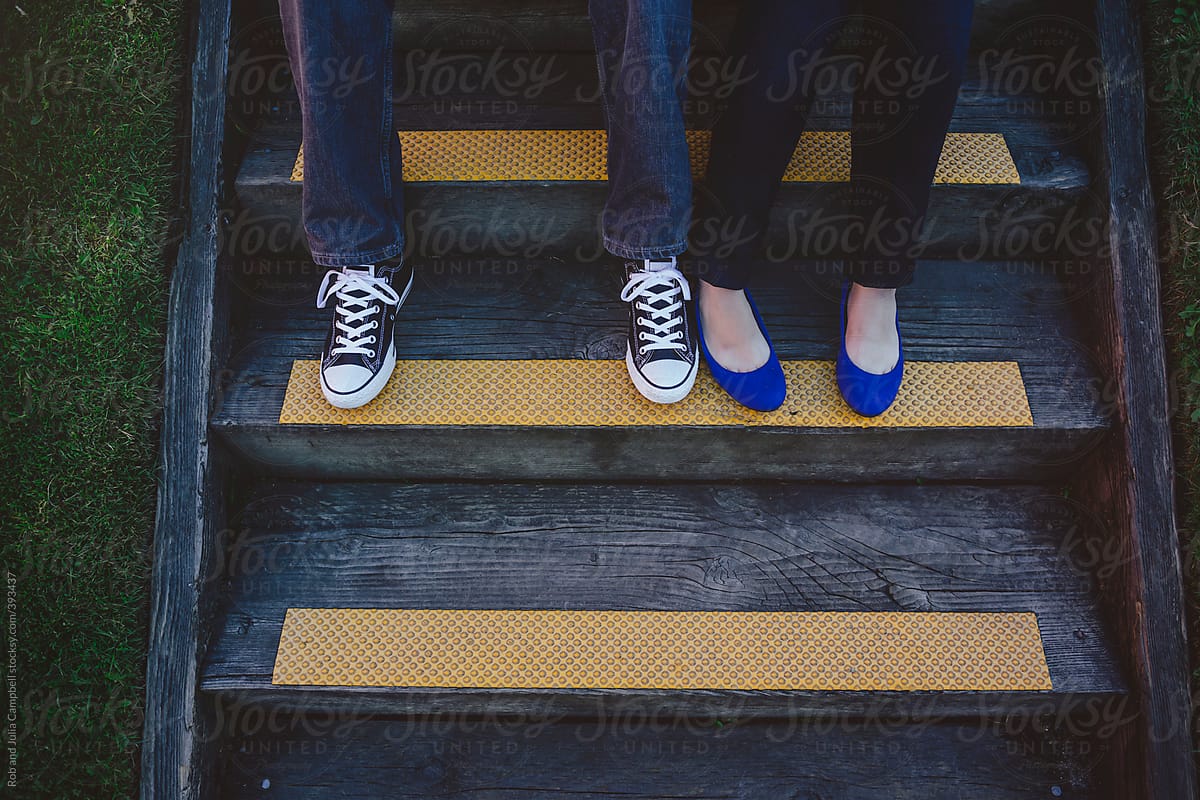Young couple\'s feet and shoes sitting on stairs
