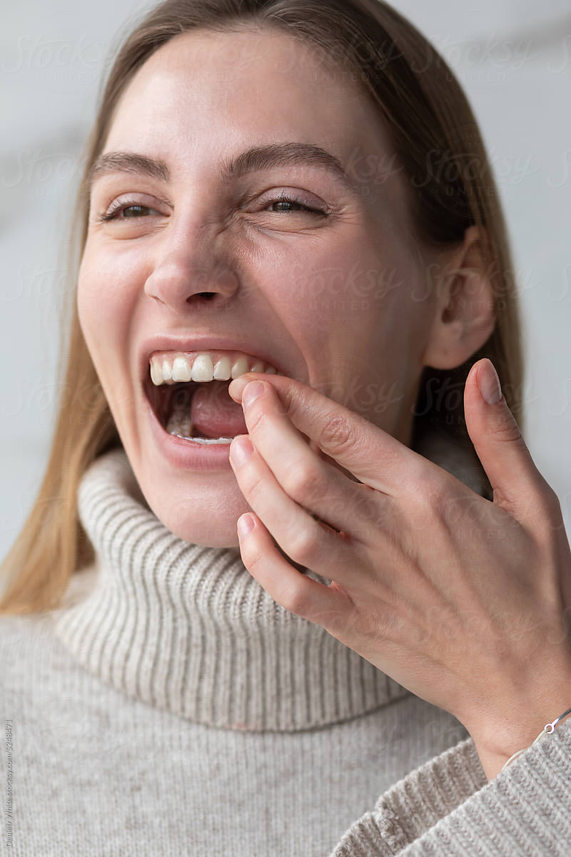White woman trying to put on a transparent dental aligner