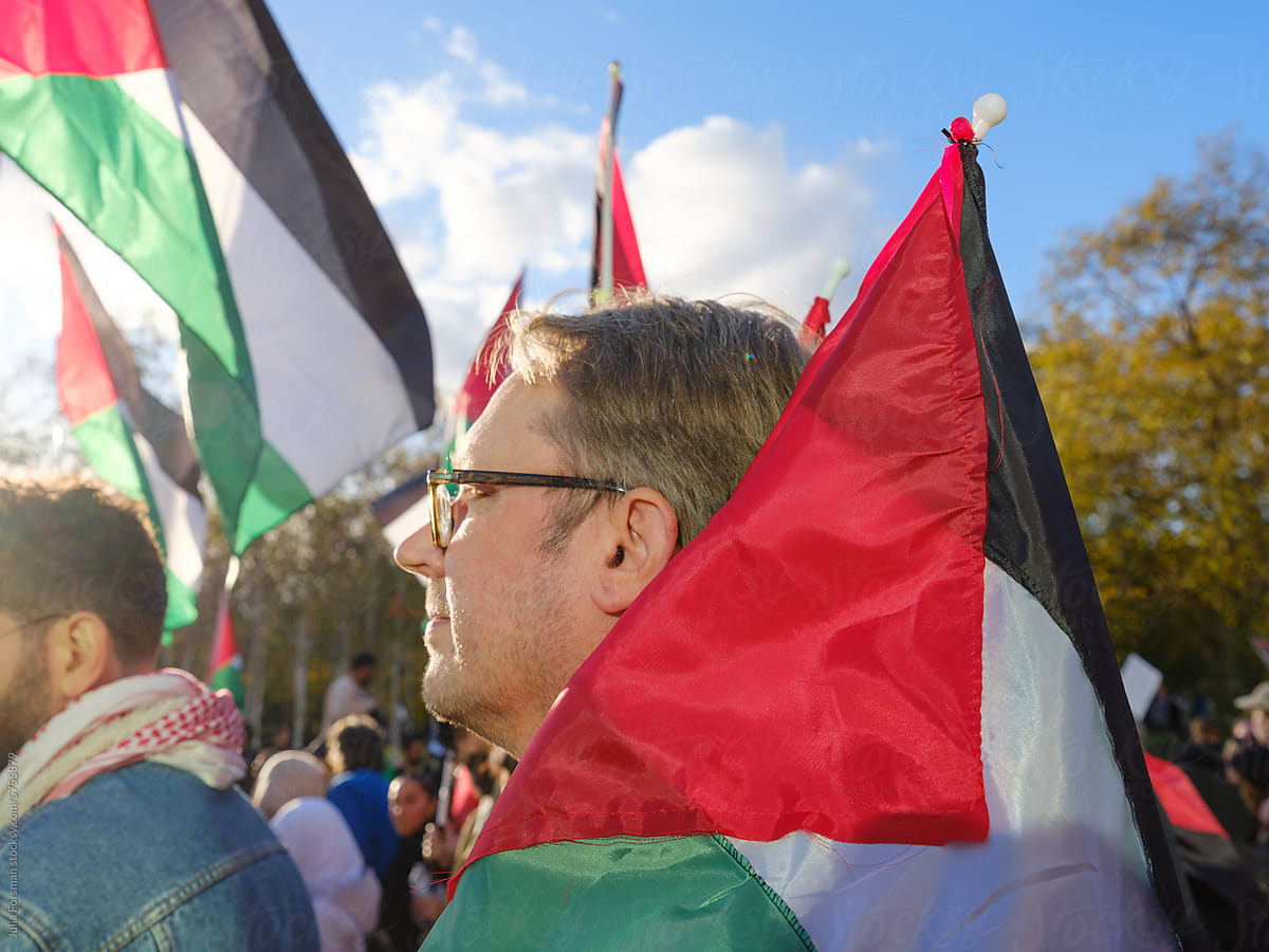 Man carrying Palestinian flag at a protest