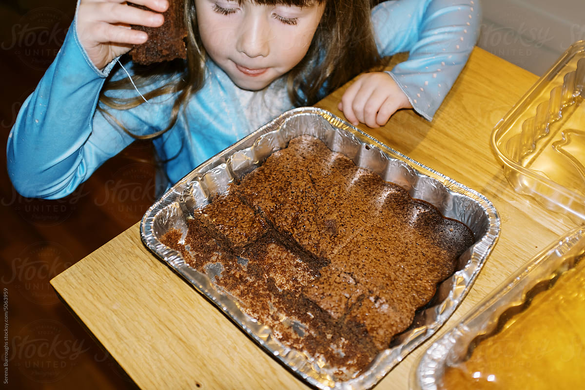Little girl taking a piece of brownie