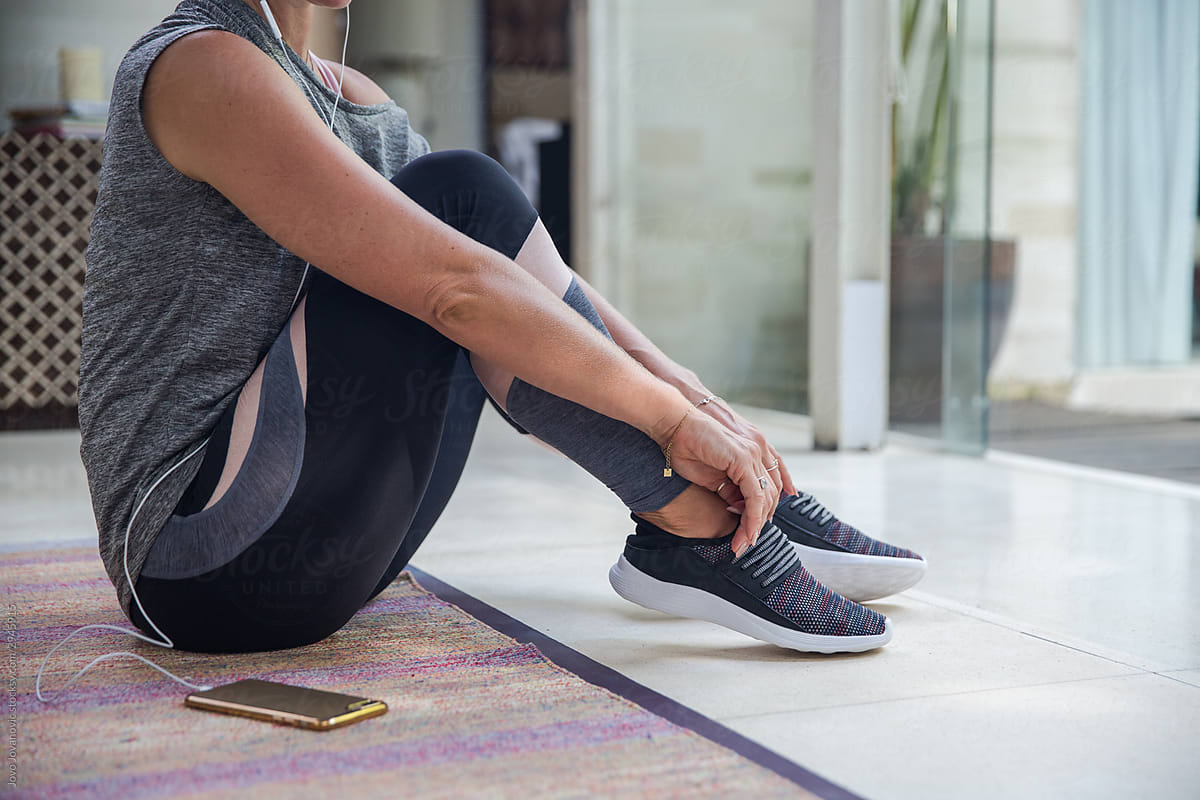 Woman putting on her shoes before exercise