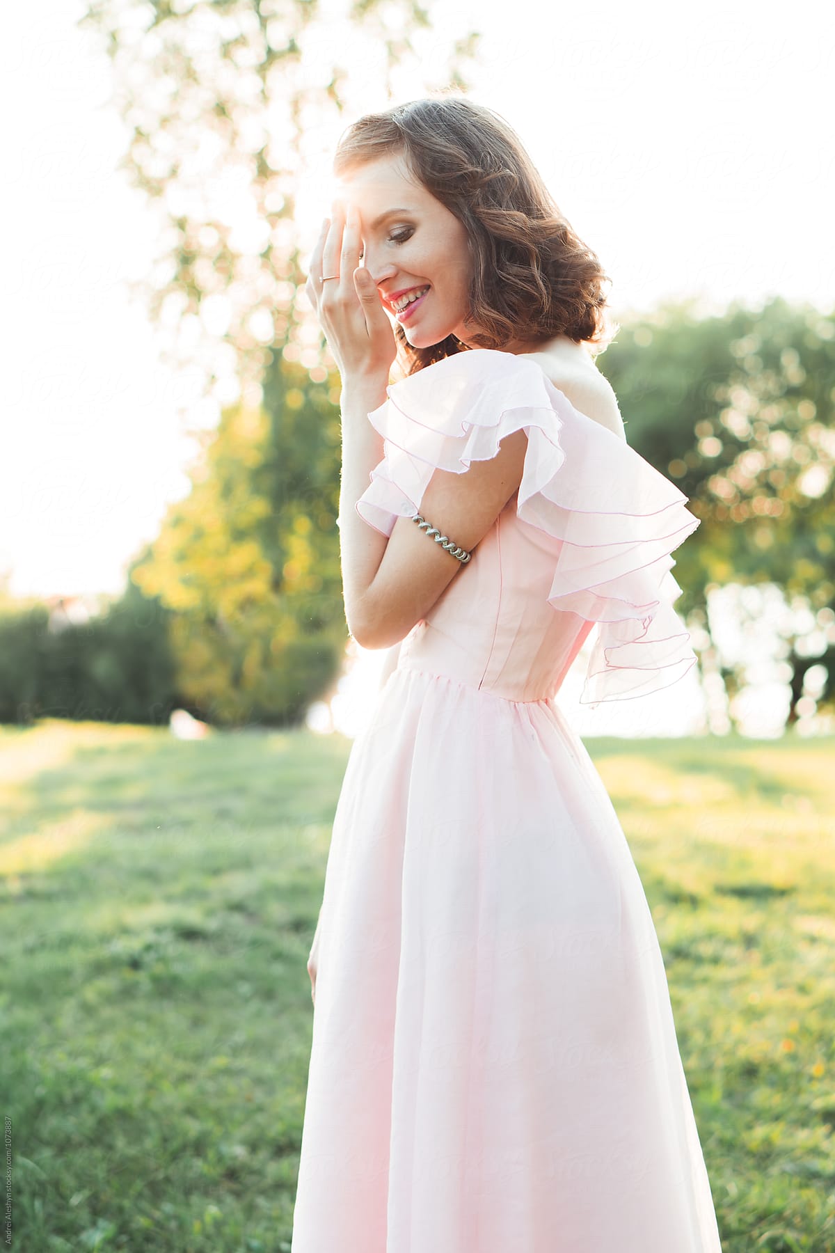 beautiful smiling girl in a pink vintage dress in summer park