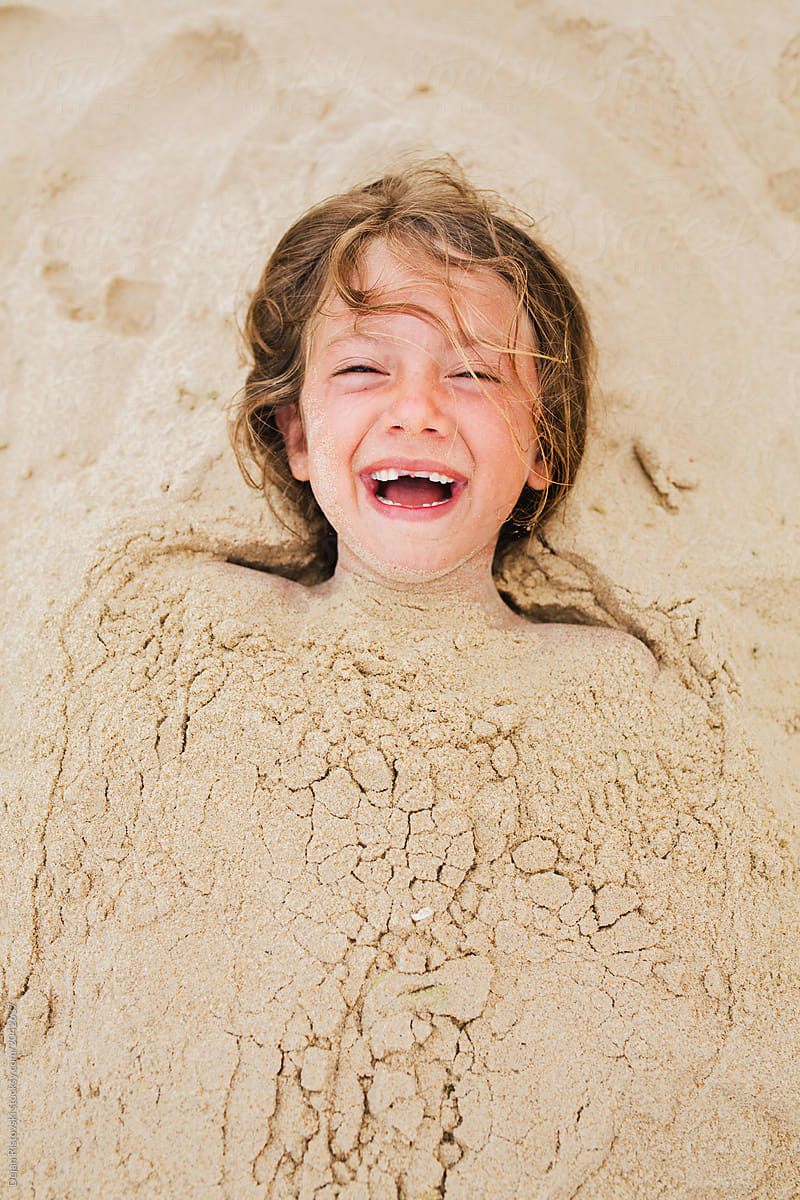 Toothless girl having fun in the sand