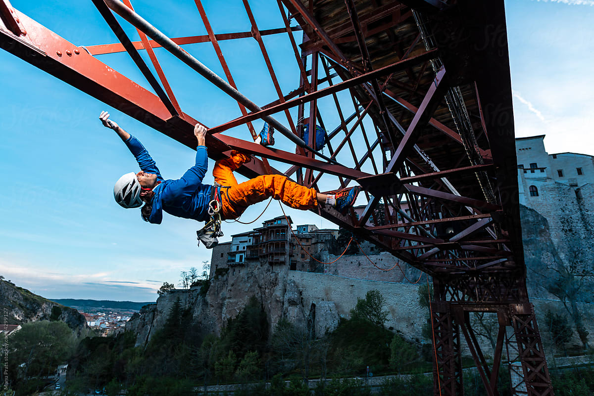 Sportsman practicing exteme sport climbing bridge
