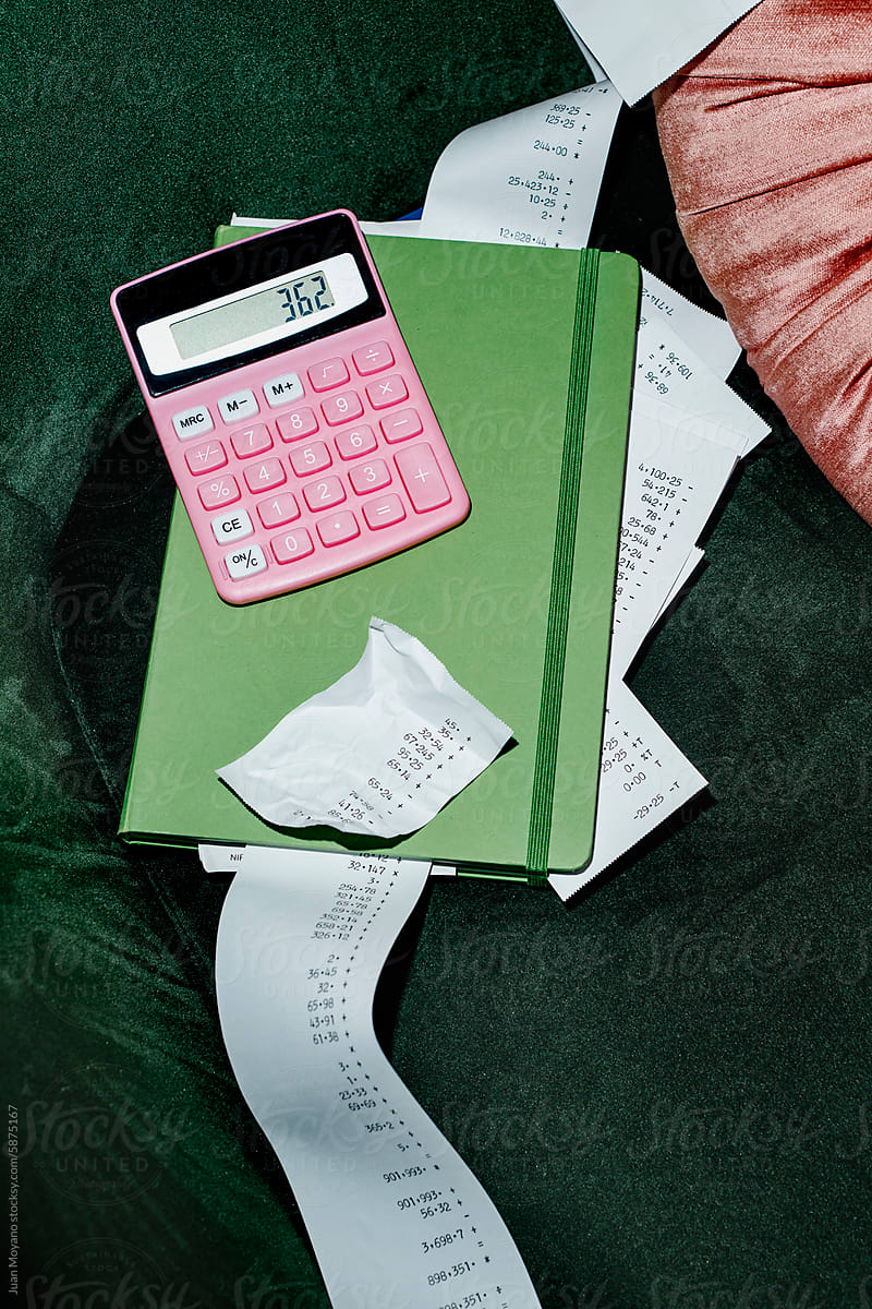 pink calculator and some strips of paper with calculations