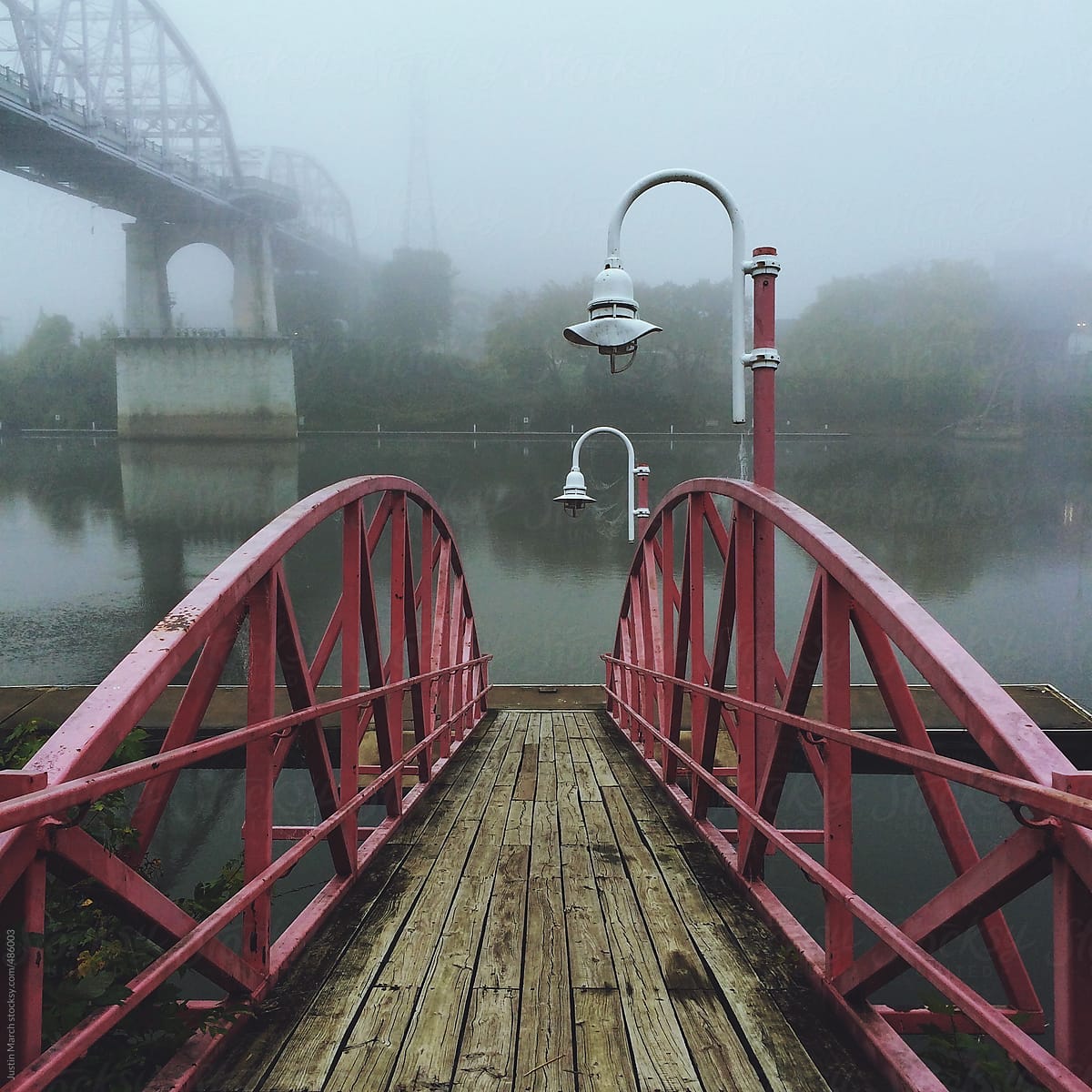 A red bridge in the morning fog