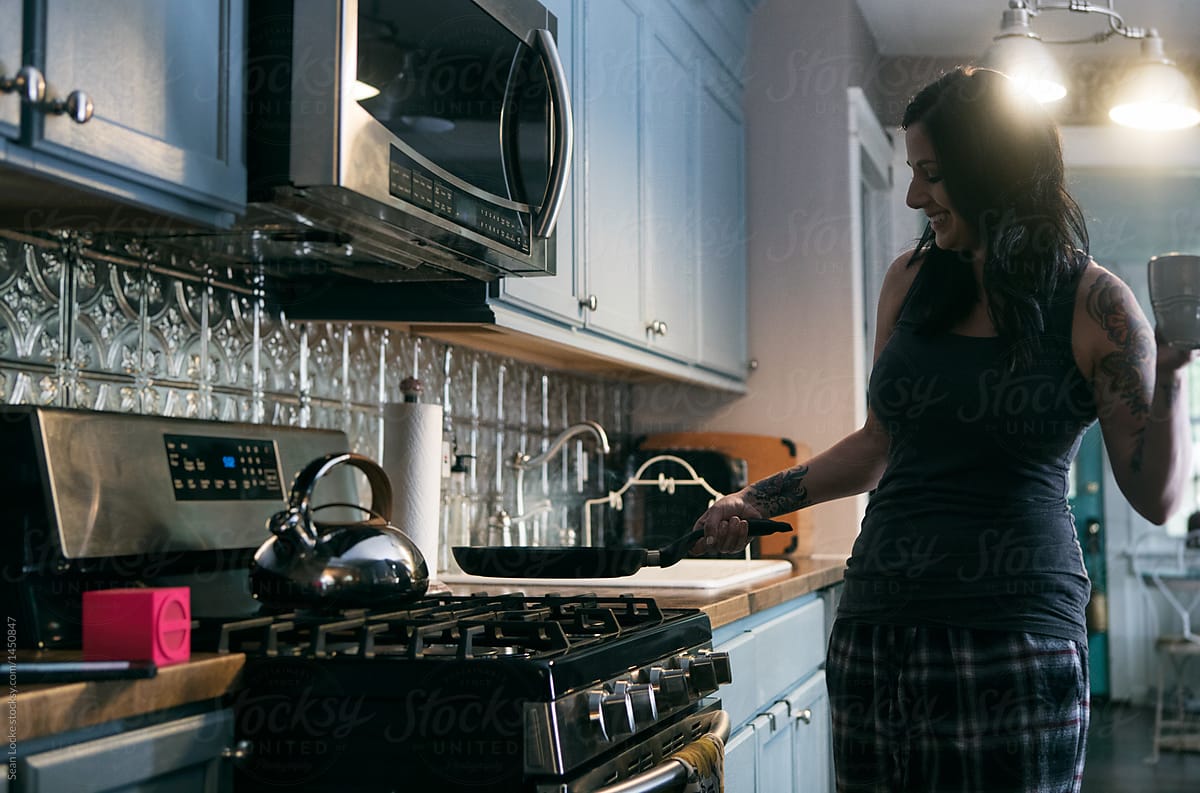 Tunes: Woman Having Fun Listening To Music While Cooking Breakfa
