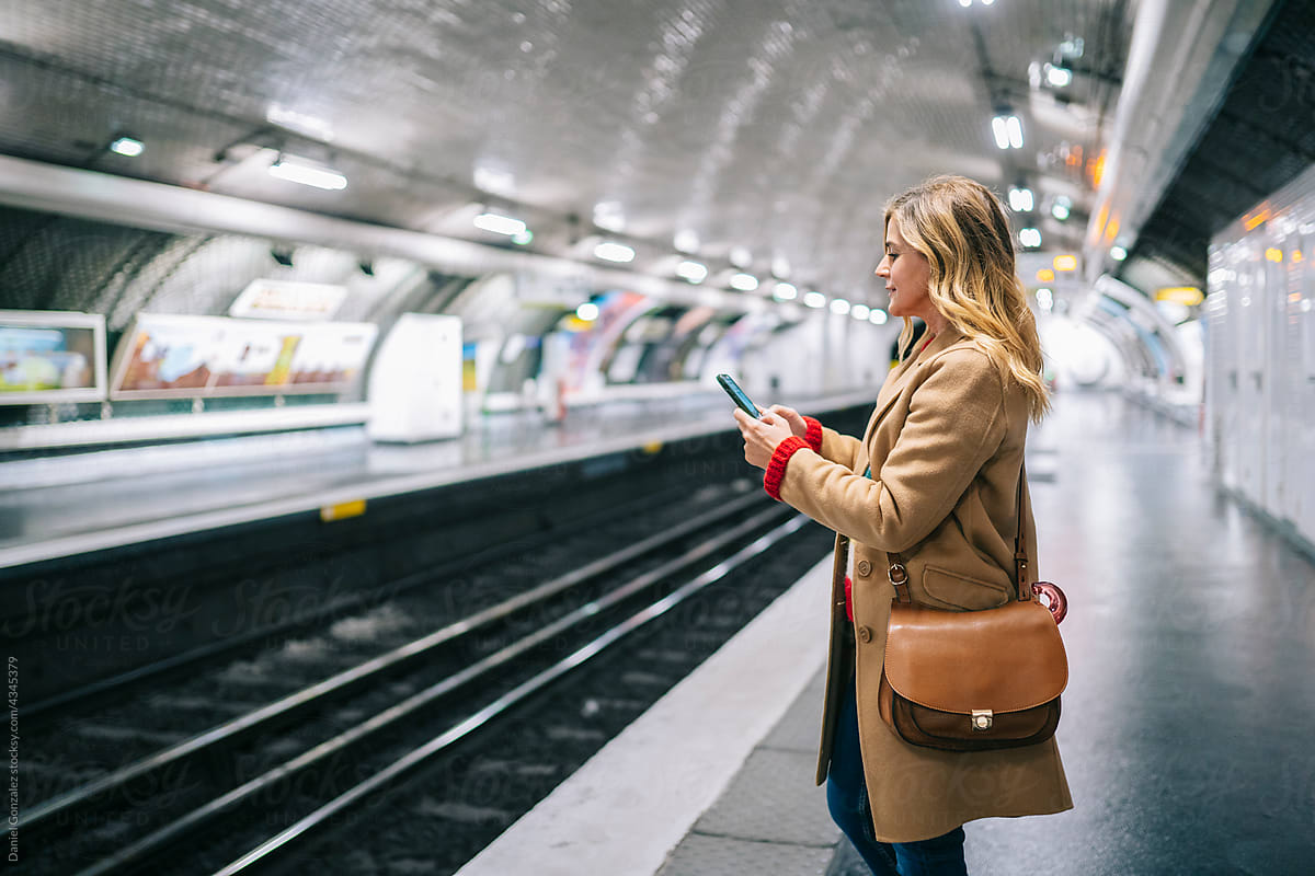 Woman browsing smartphone in metro
