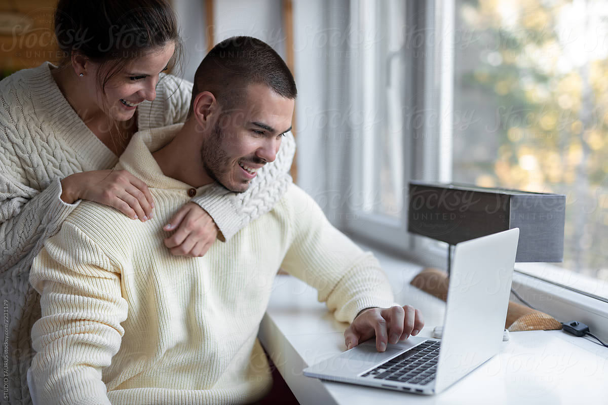 Young couple at home using laptop