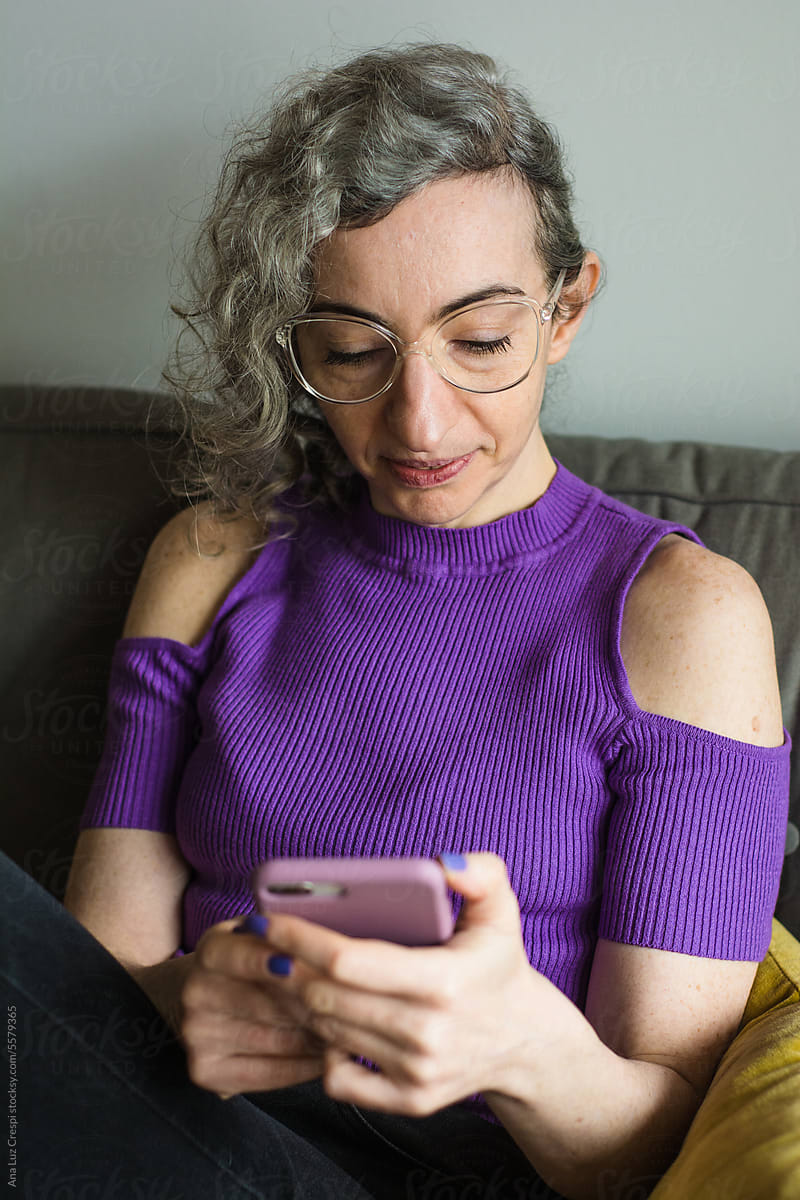 Adult grey hair woman using internet with smartphone