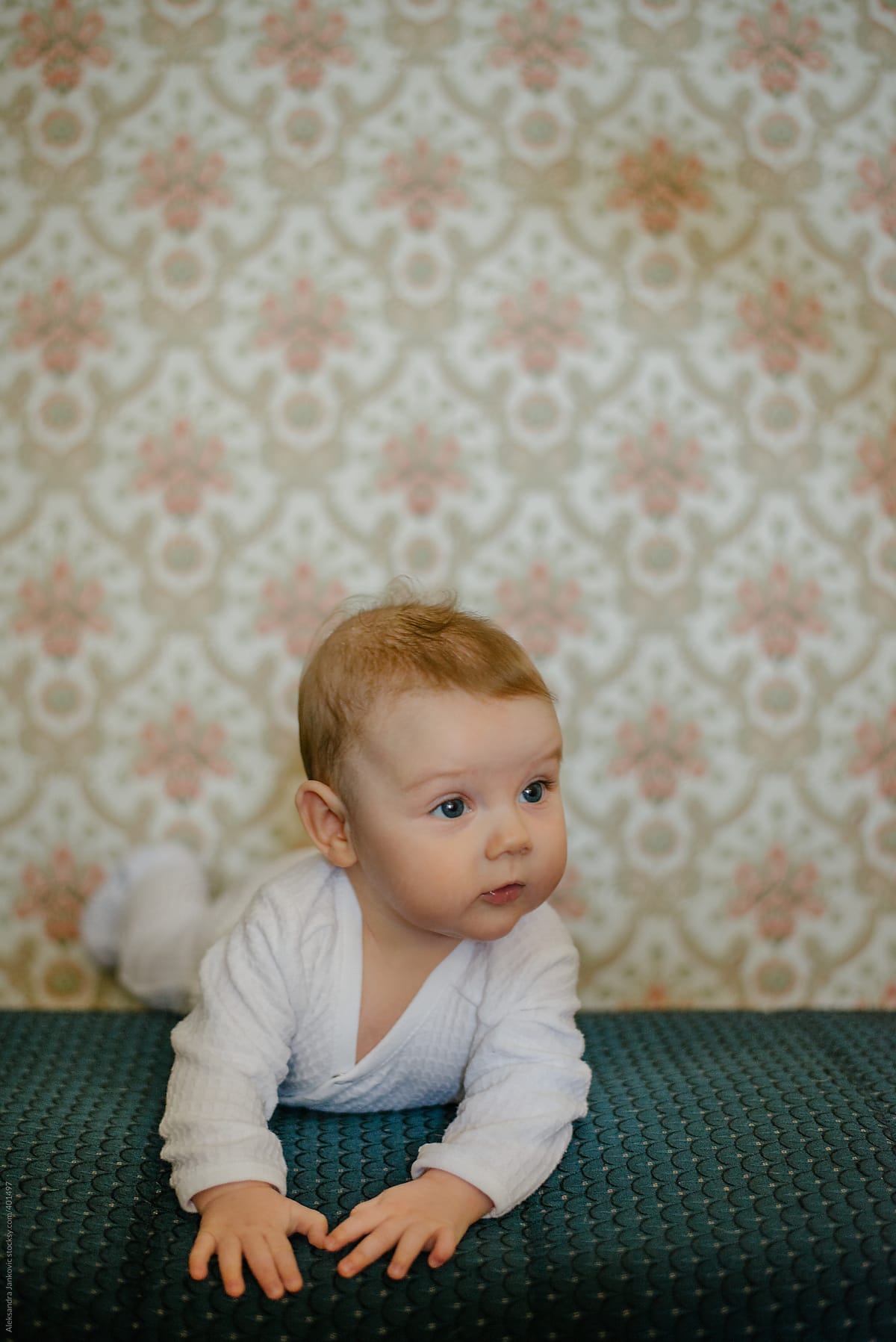 Cute Baby Girl Portrait In Front Of The Vintage Wallpaper