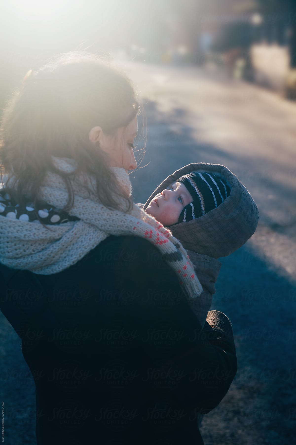 Baby boy in his mother\'s arms going for a walk in a park in winter