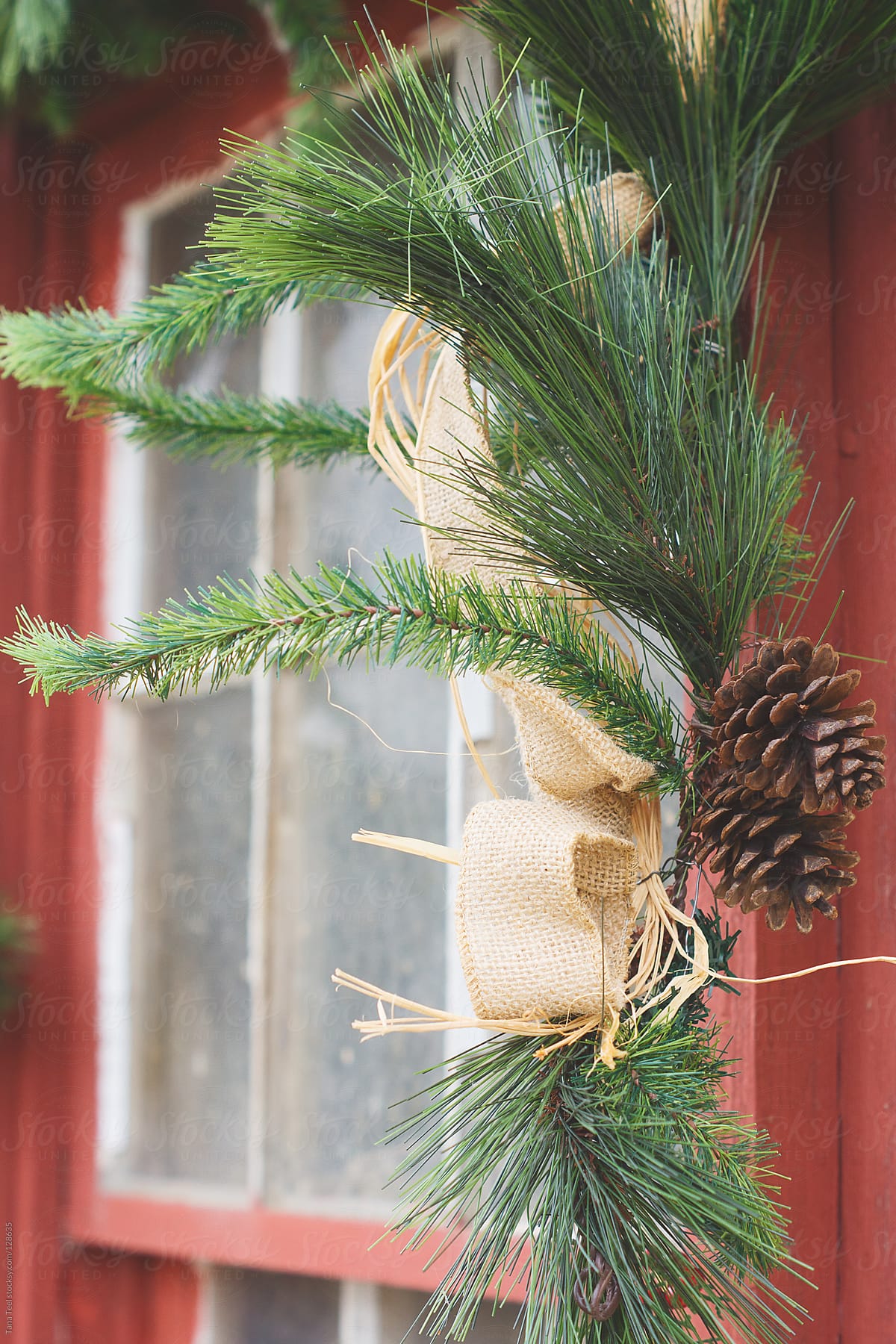 A rustic evergreen hangs from an old window for the holiday season