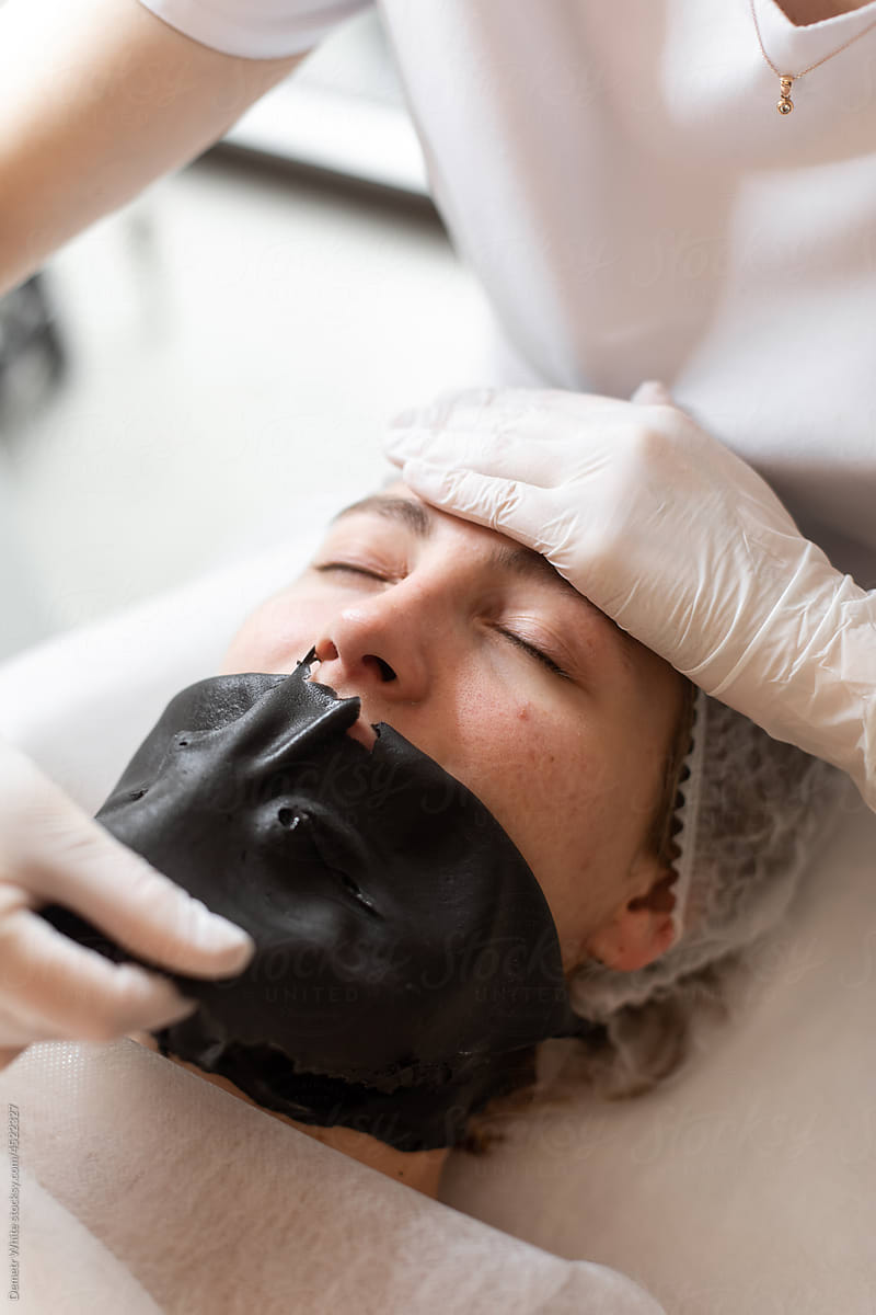 Black peeling mask on face of woman