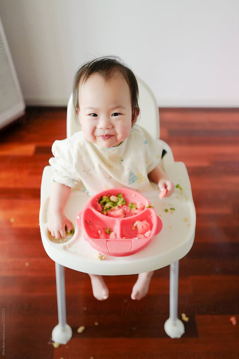 One-year-old asian babygirl eating lunch for herself