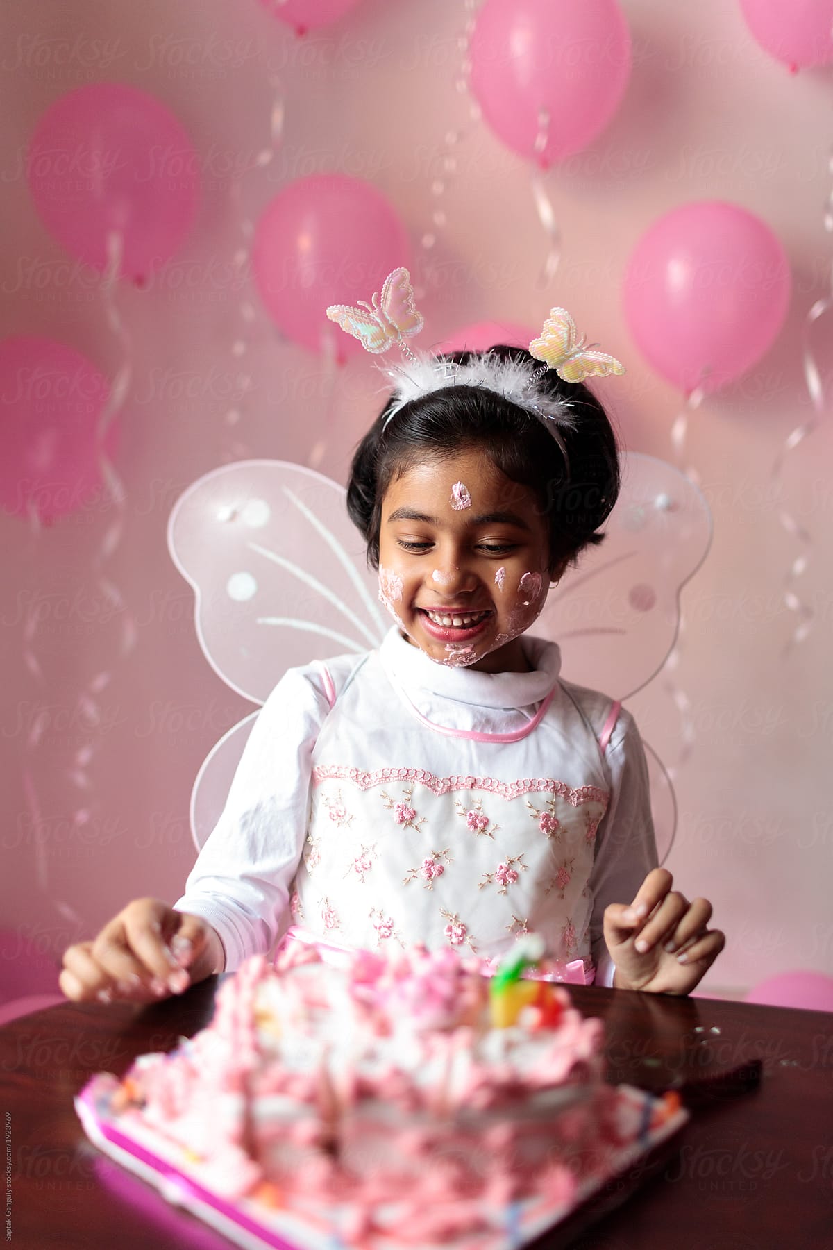 Cute little girl enjoying her birthday cake