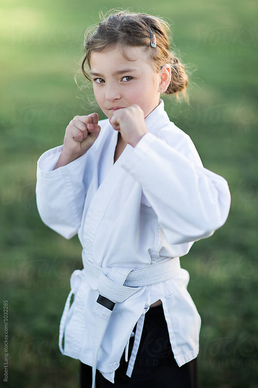 Girl doing martial arts outside on grass