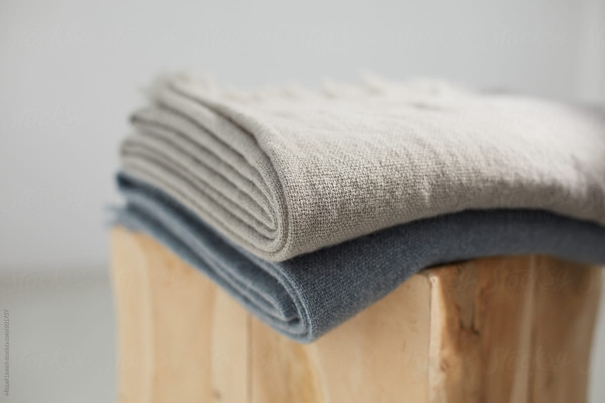 Two wool blankets on a wooden stool