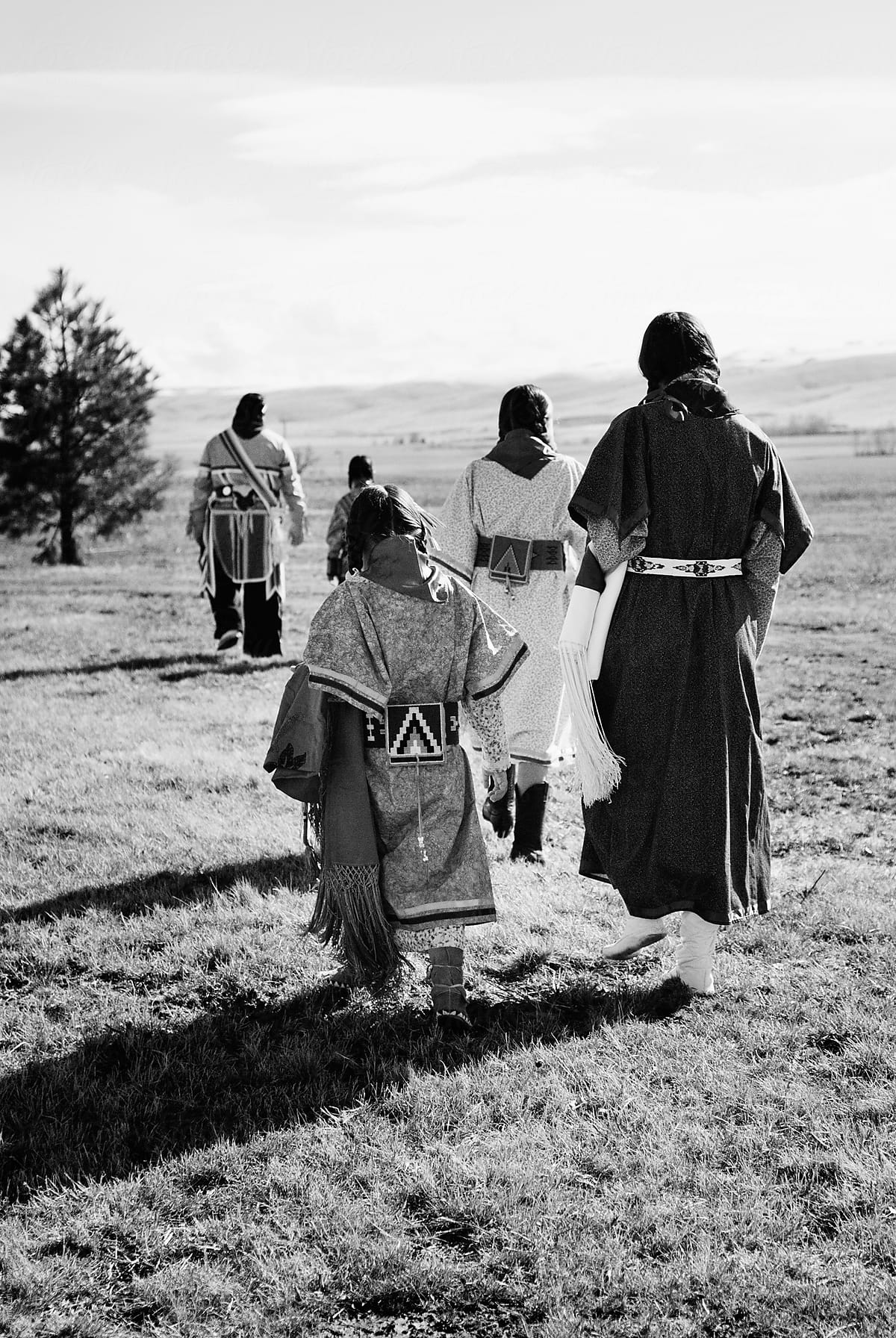 A Native American family walks together in a field