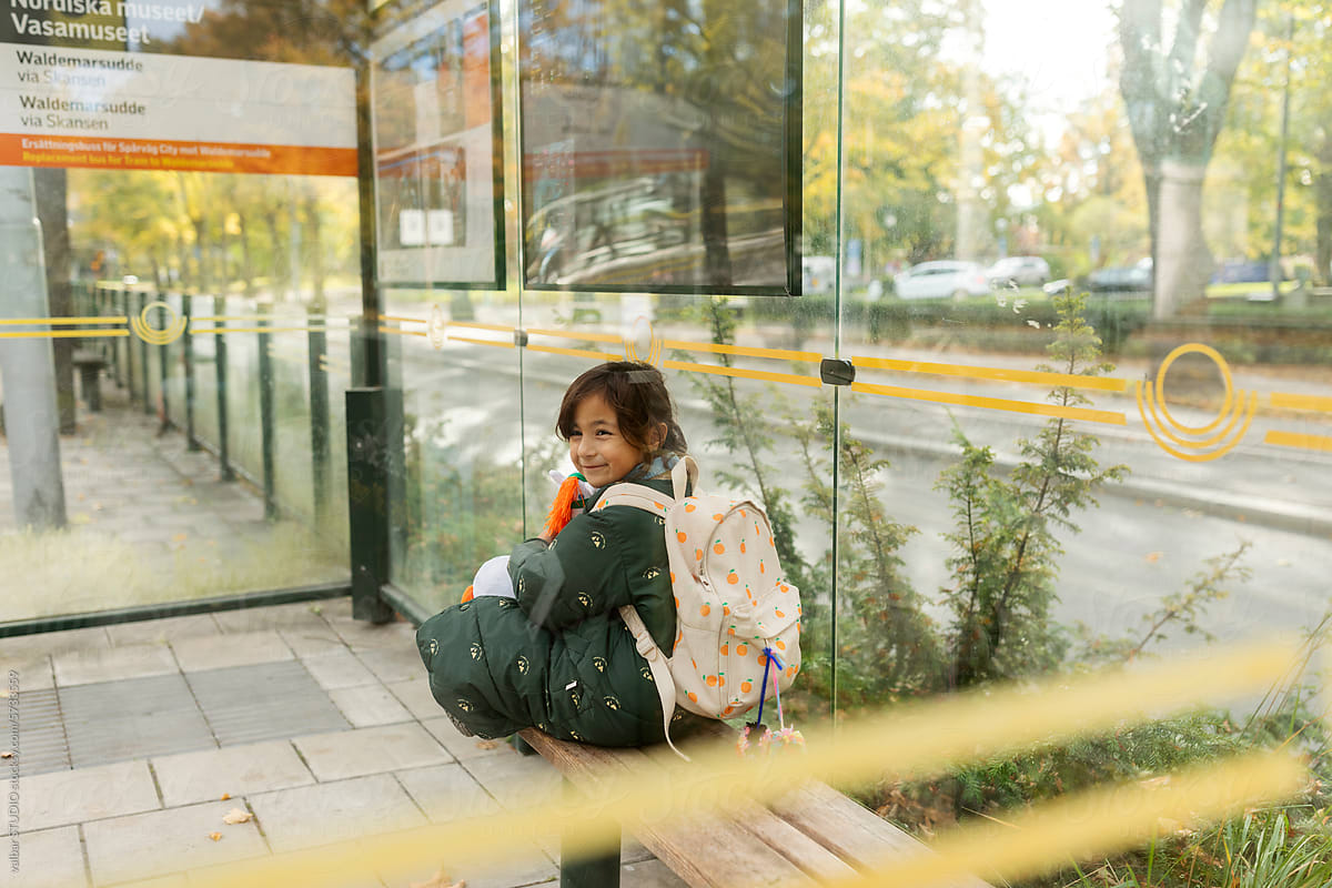 Young girl sitting at bus stop