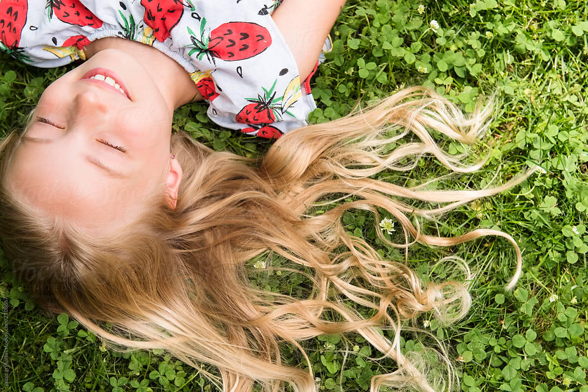 Close Up Of Girl Lying In Grass By Stocksy Contributor Jamie Grill