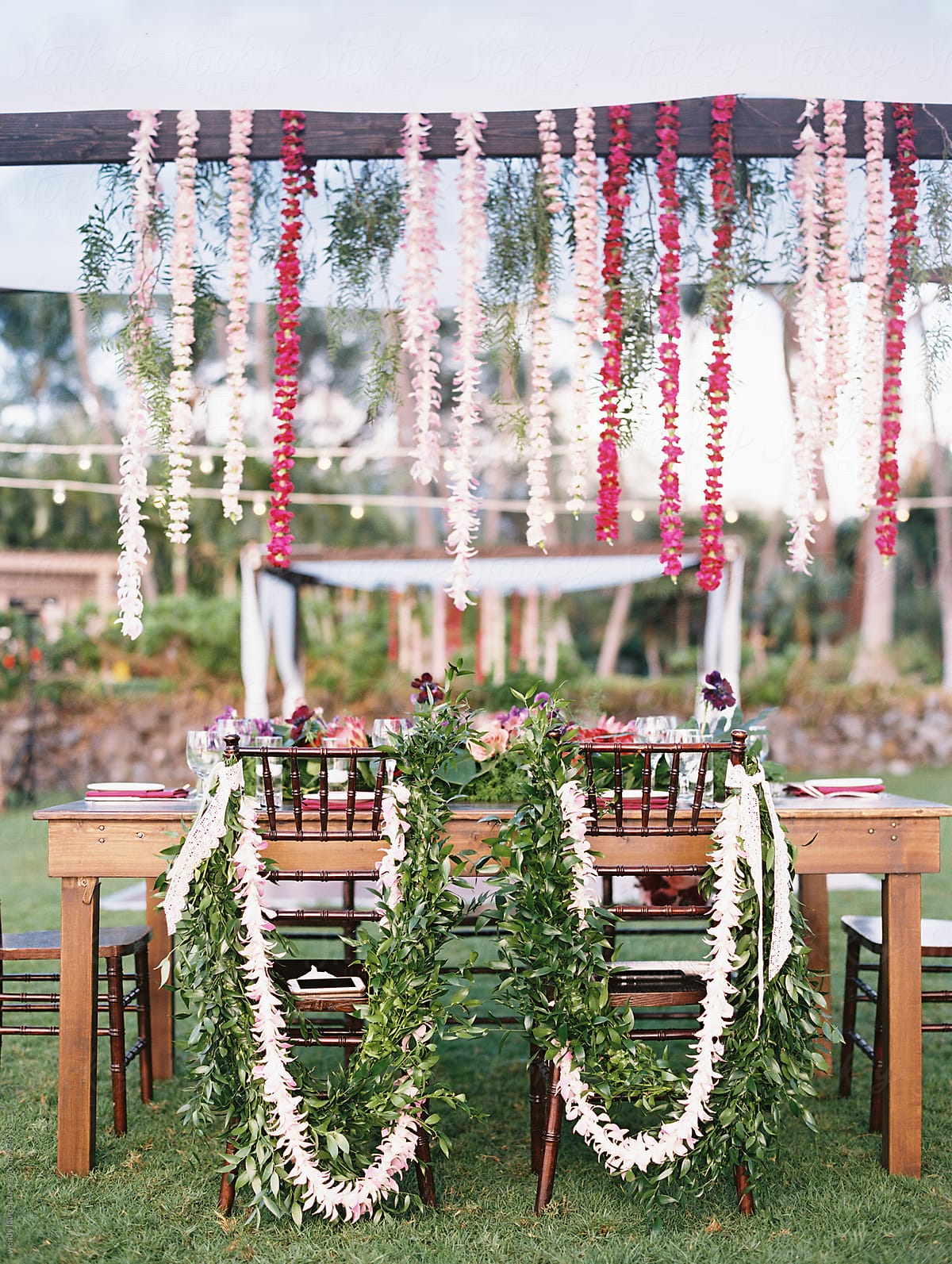 wedding table set up with hanging floral strings and floral decorated chairs