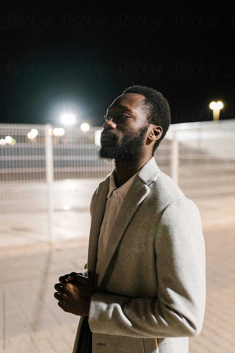 Black man on street in night city