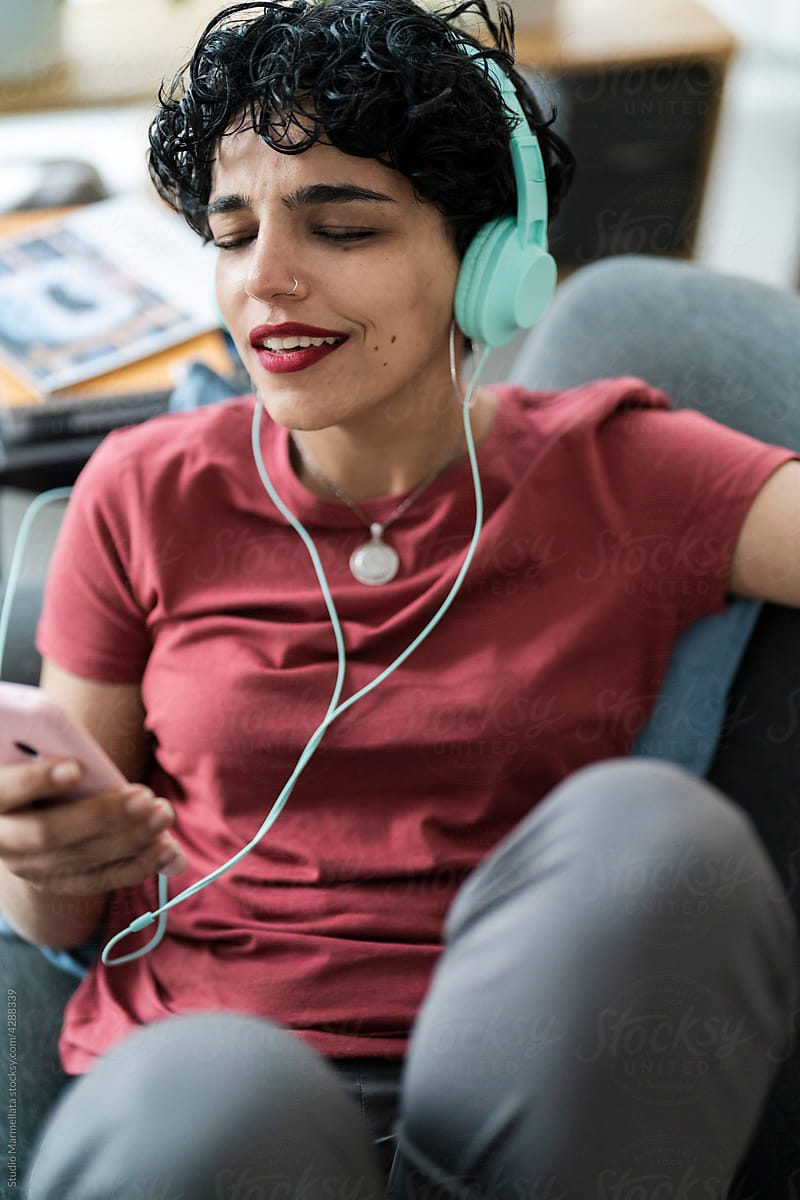 Smiling woman in headphones singing songs