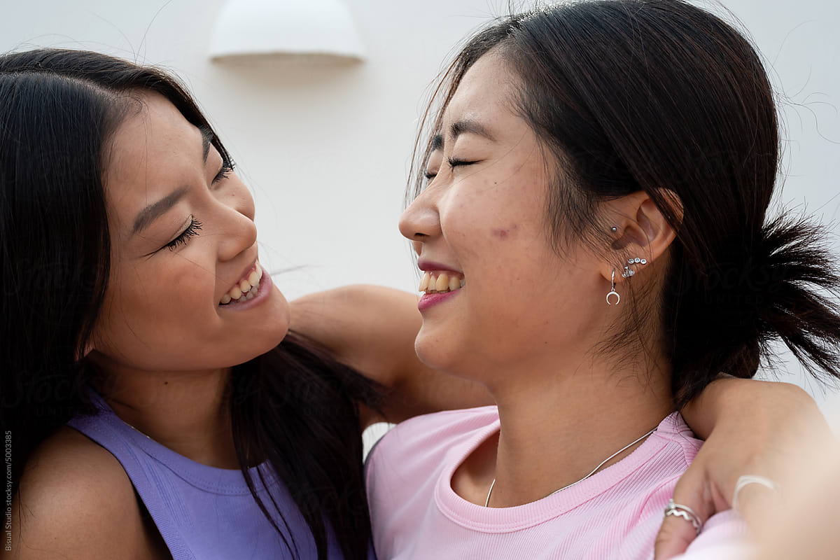 Two Happy Asian Female Friends hugging