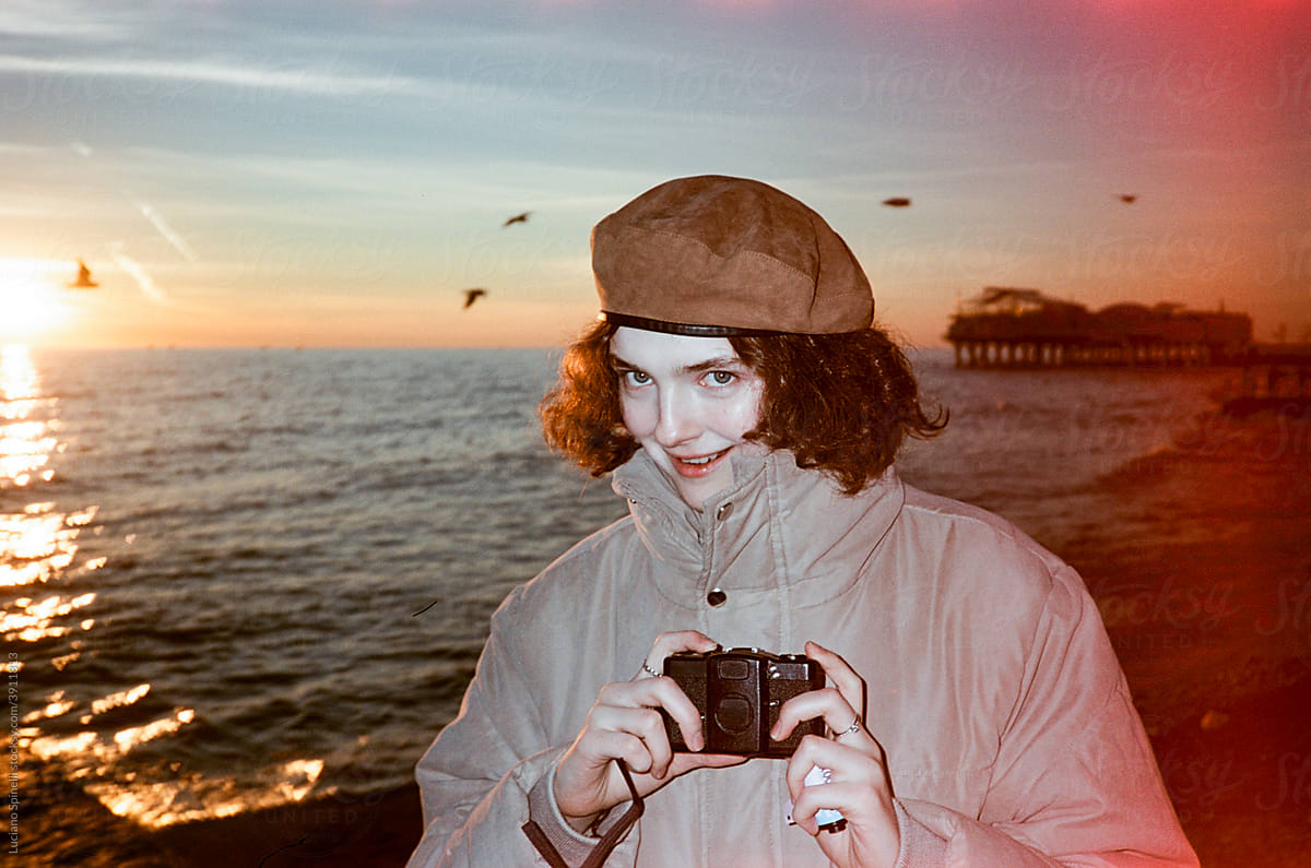 Girl with a vintage analog film camera in the beach