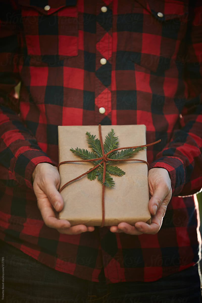 Man holding homemade wrapped Christmas Present