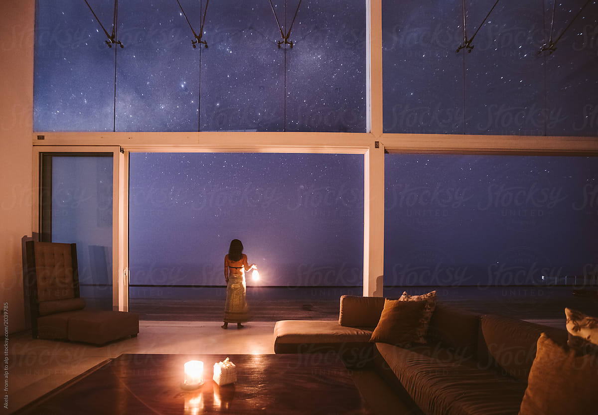 beautiful woman with lantern enjoying the milky way from a luxur