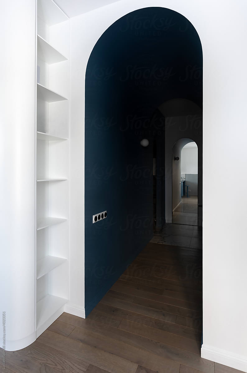 round dark corridor with a white shelf and a gray book