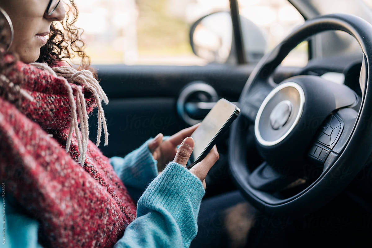 Focused woman using mobile in car