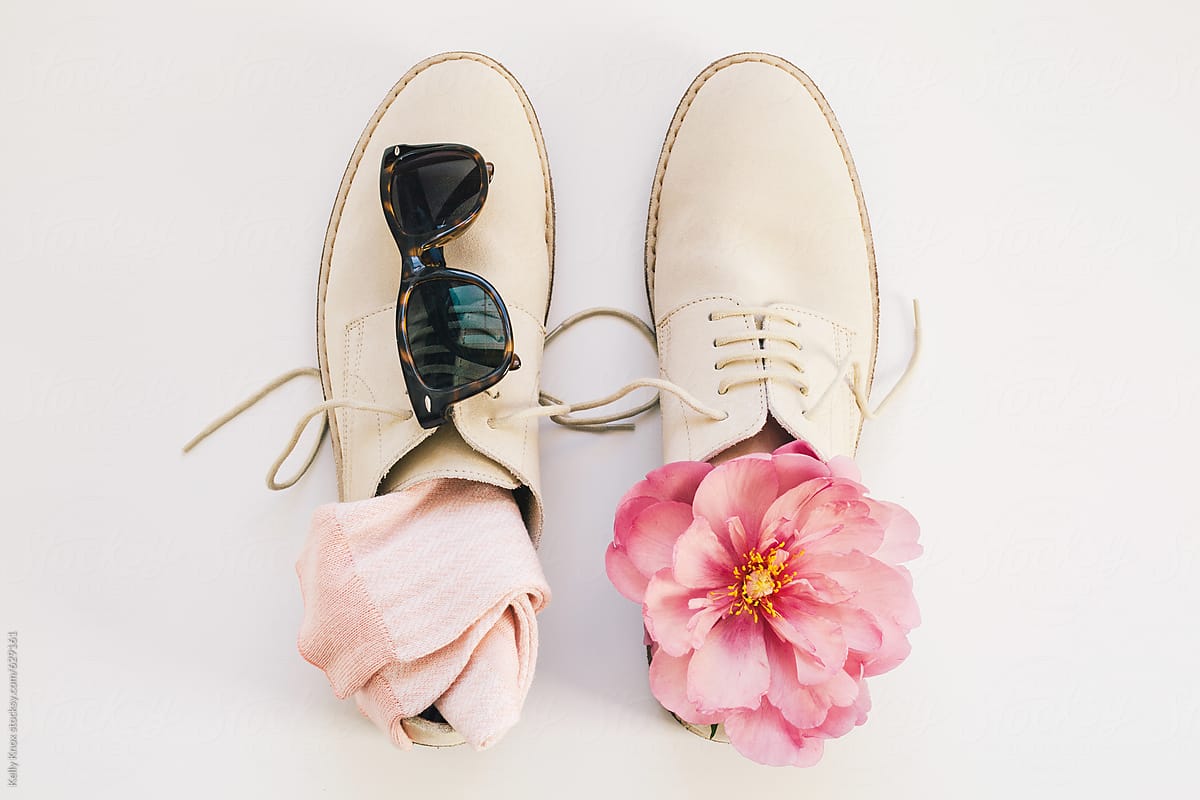 man\'s shoes, socks, sunglasses, and spring flower