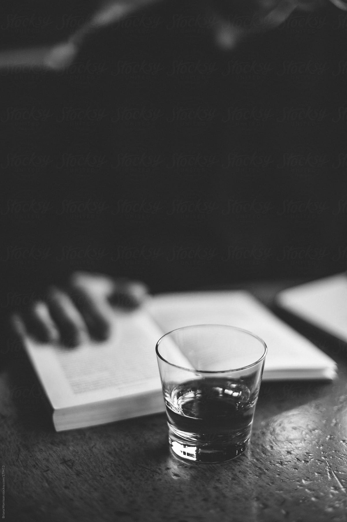 Glass of Scotch and Man Reading a Book