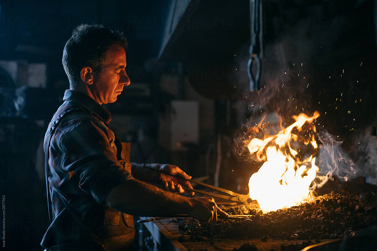 Blacksmith heating iron in fire
