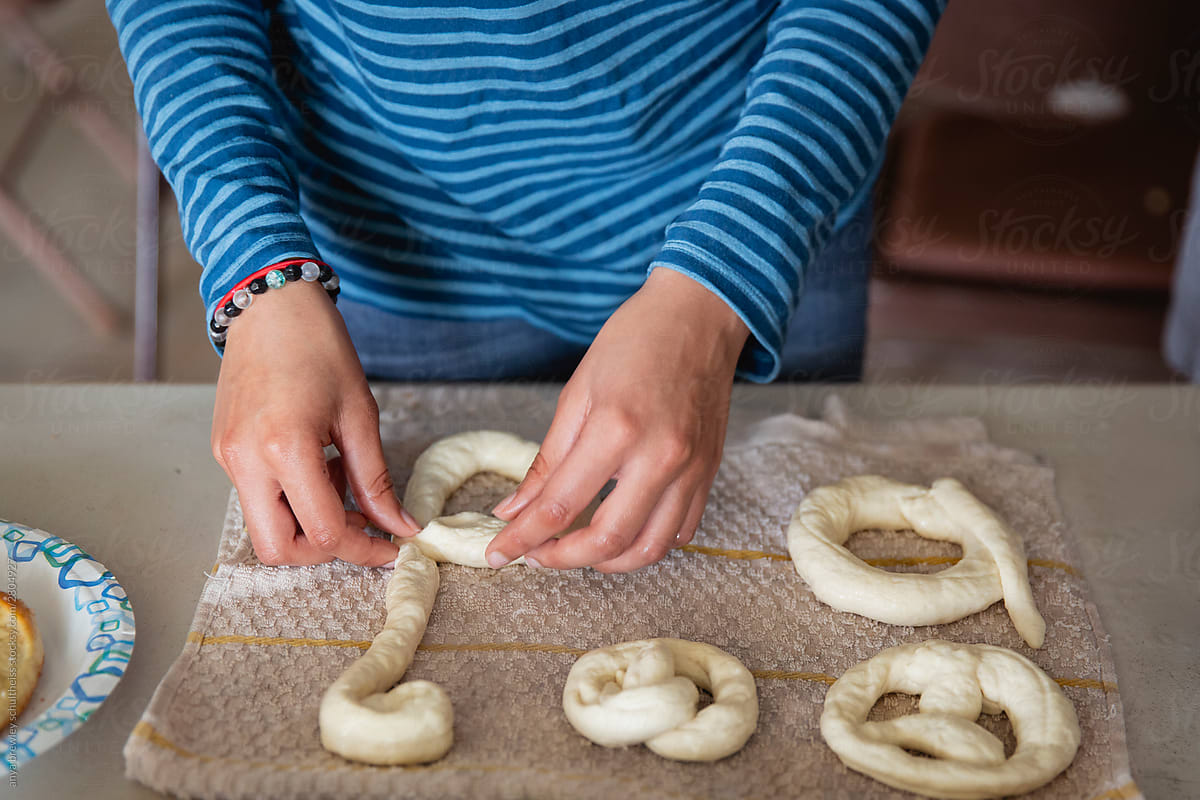 A pair of hands placing wet raw dough on a clean cloth
