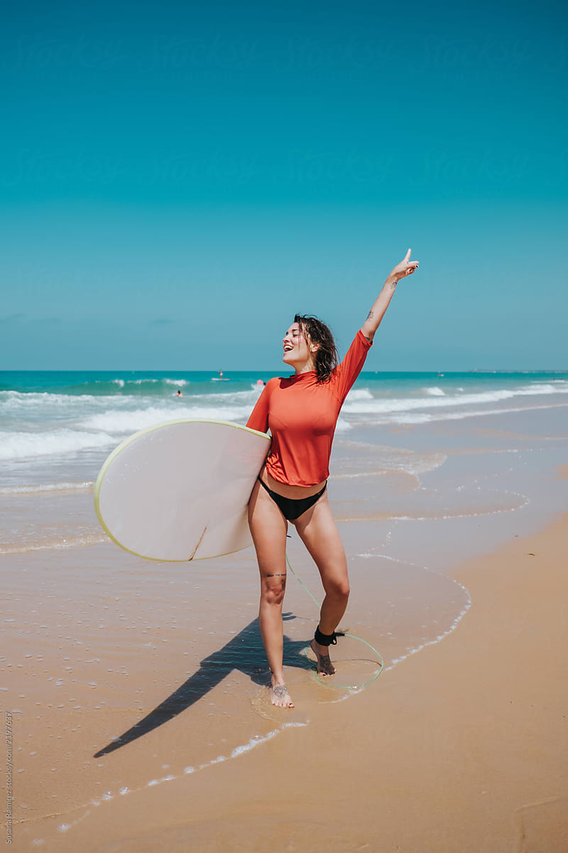 Woman with surfboard on the seashore
