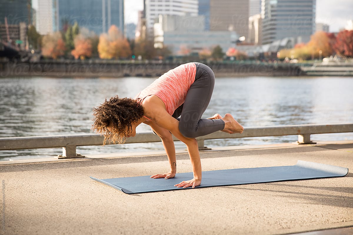 Mixed race female doing yoga on a waterfront