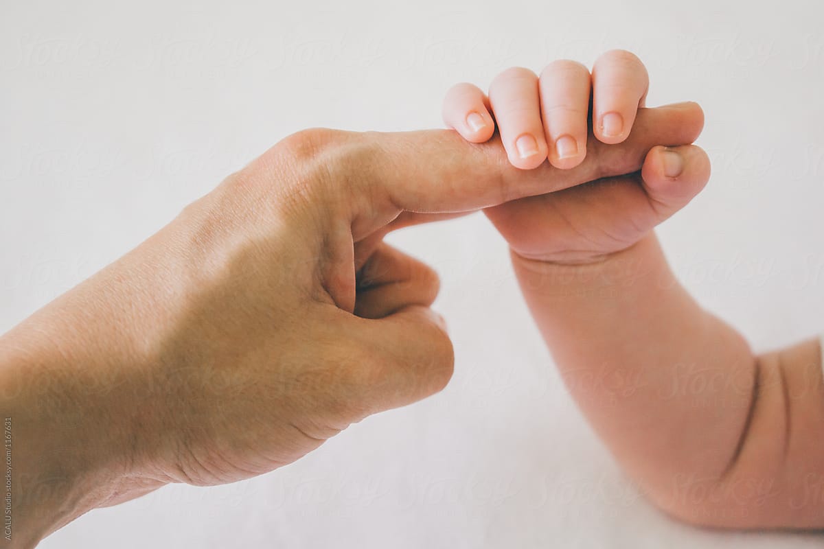 Baby hand taking her mother's finger