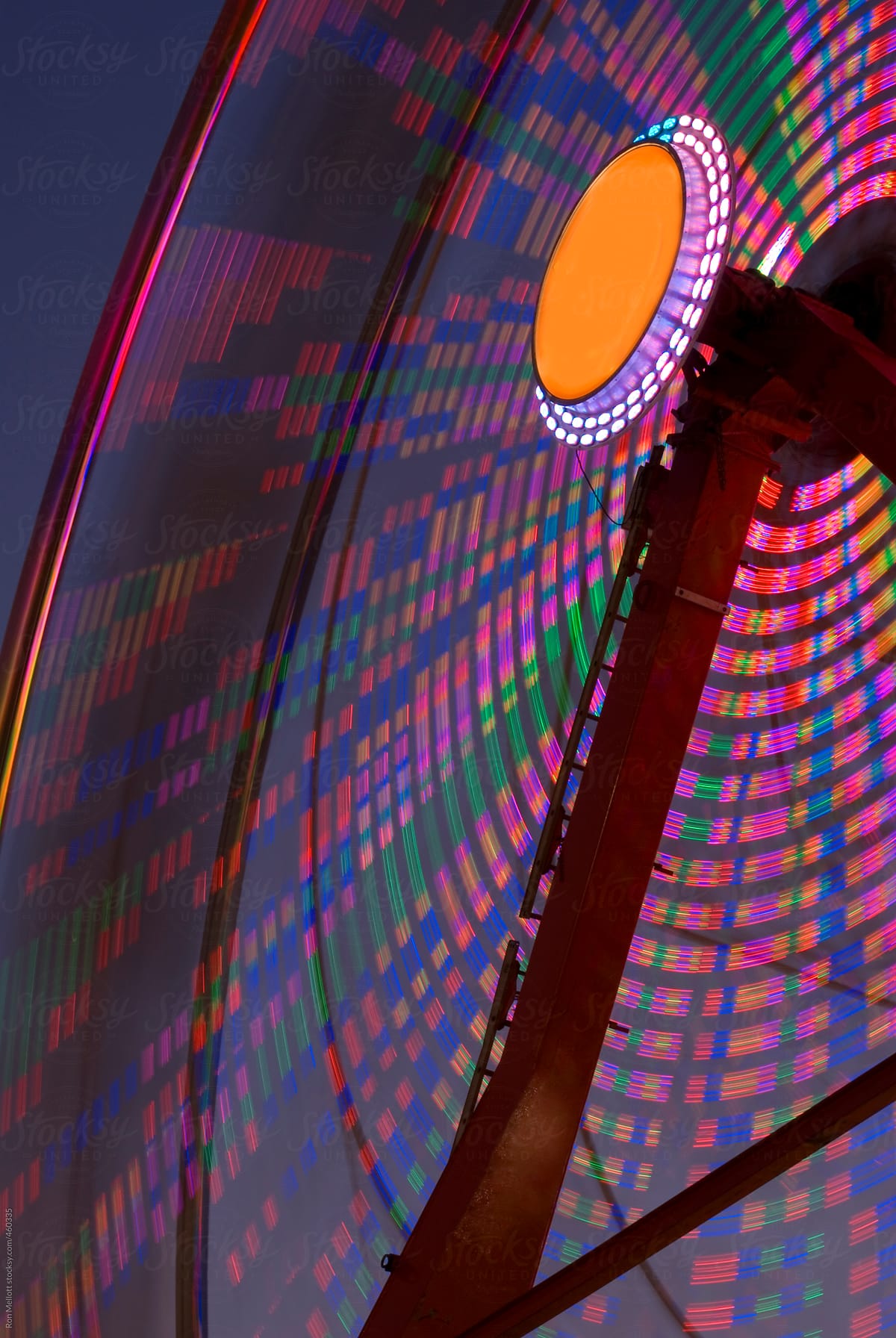 time exposure nighttime ferris wheel state fair amusement park color bands patterns