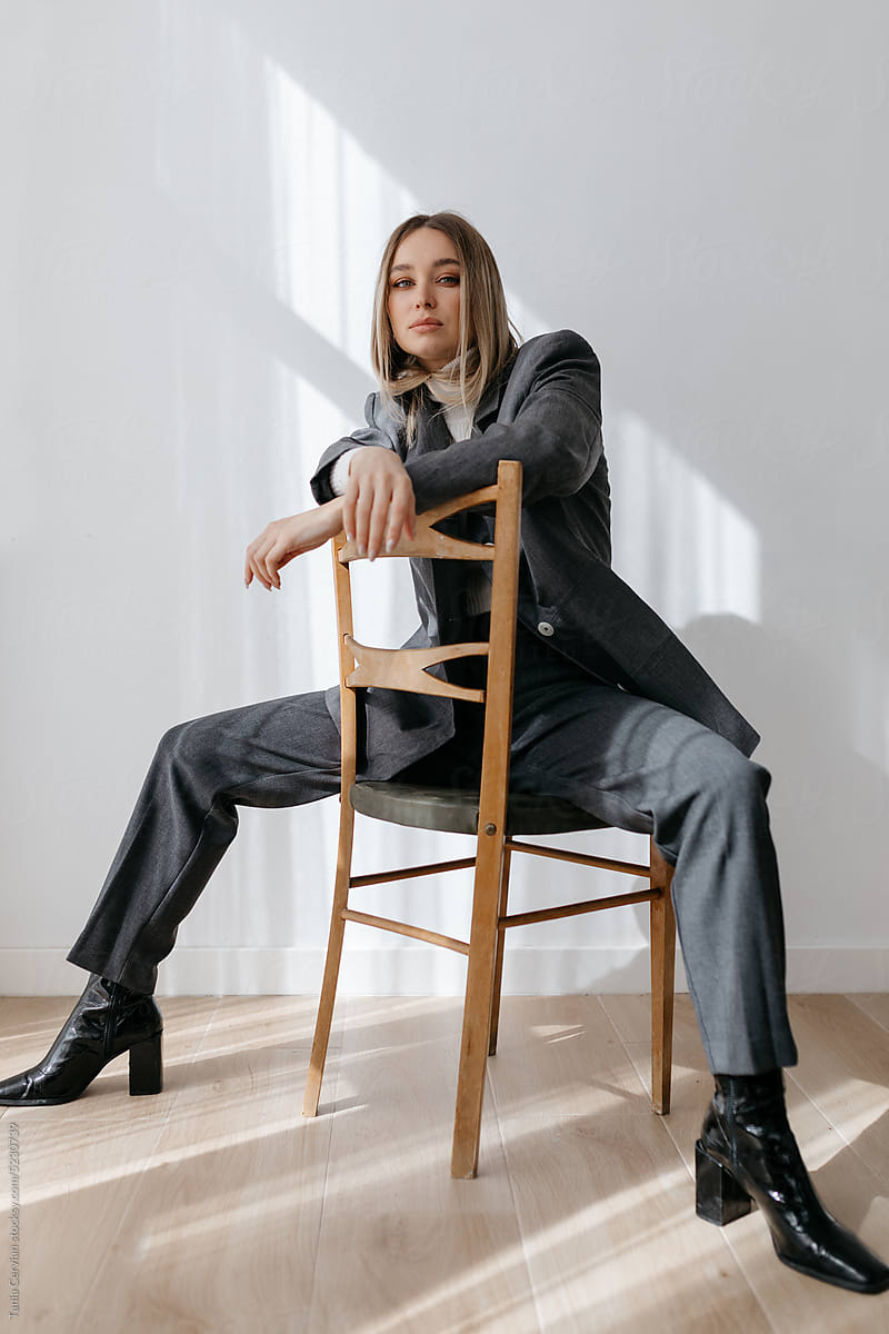 Stylish woman sitting on chair with crossed hands