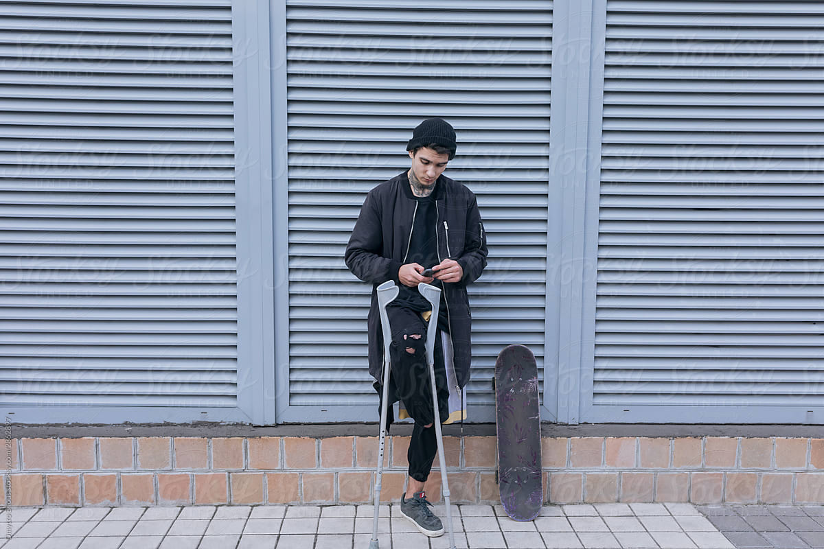 photo of a guy without a foot with a skateboard on grey background