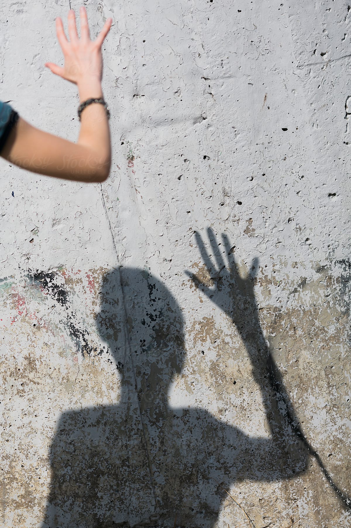 hand of  woman and her shadow on the grunge wall