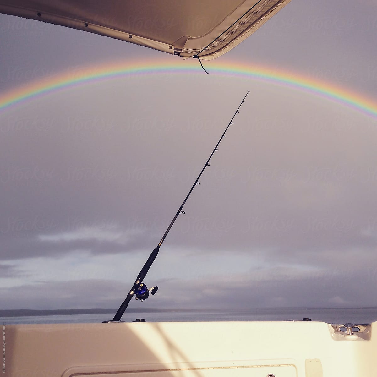 fishing rods on the back of a boat, with a rainbow