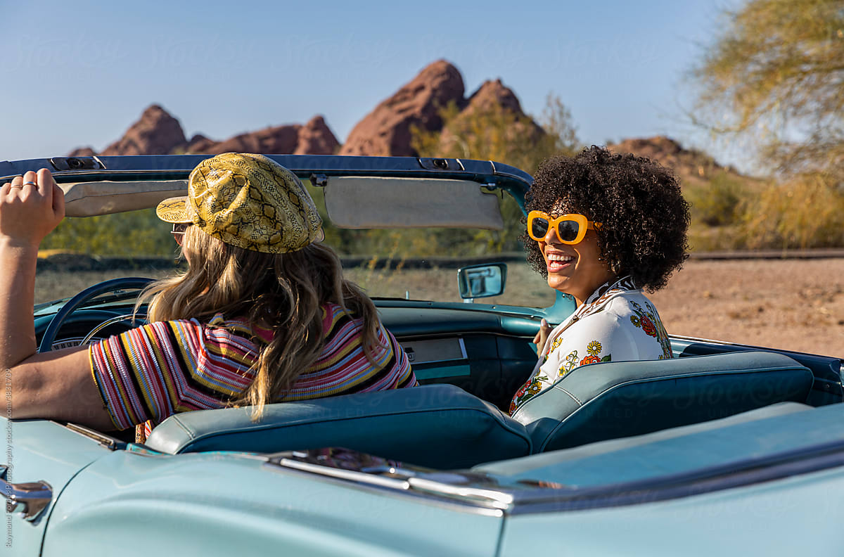 Two young girls Talking in Vintage car on road trip