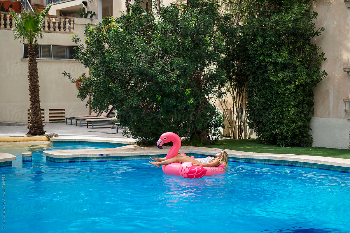 Traveler sunbathing on inflatable flamingo