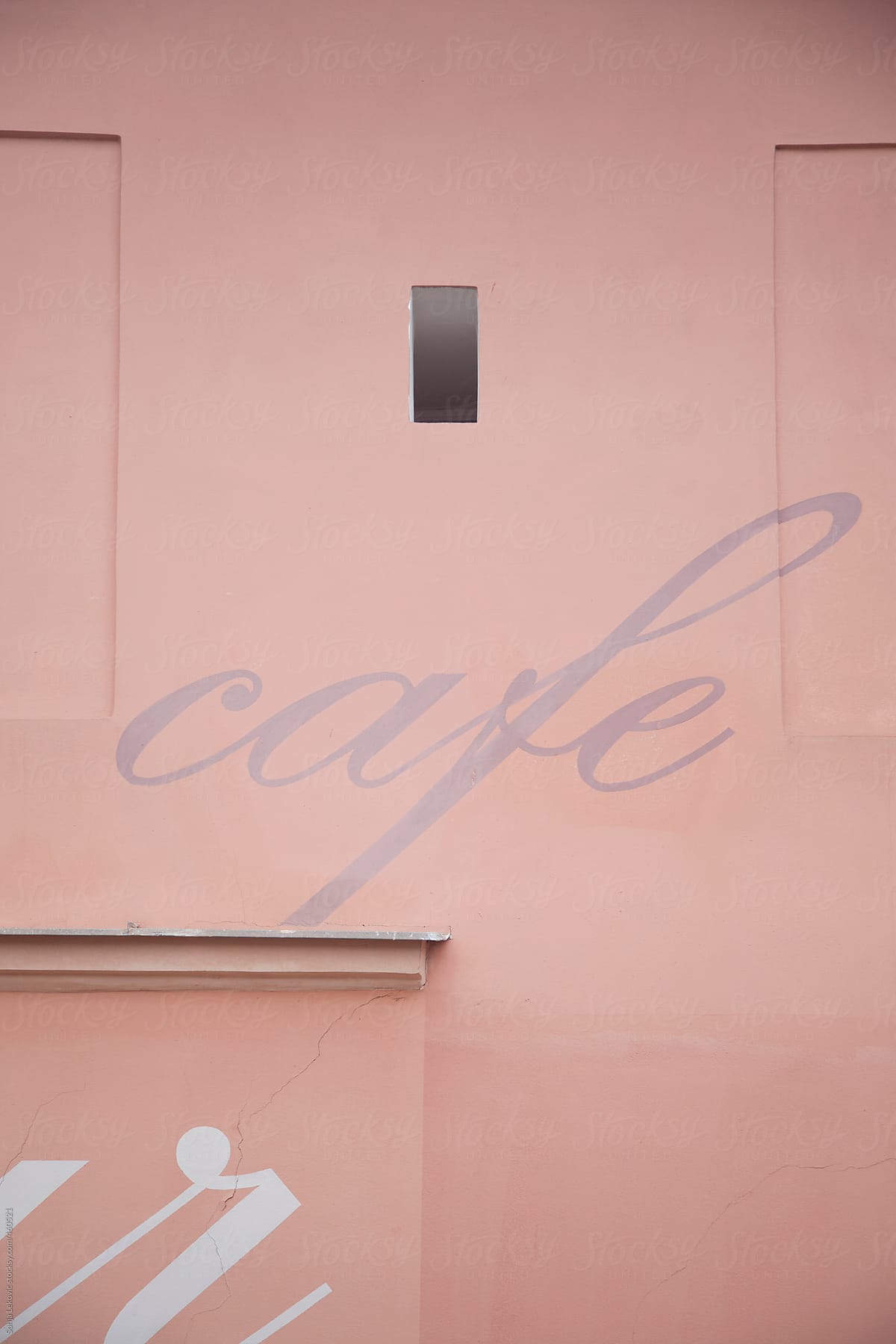 cafe sign on a pink building wall